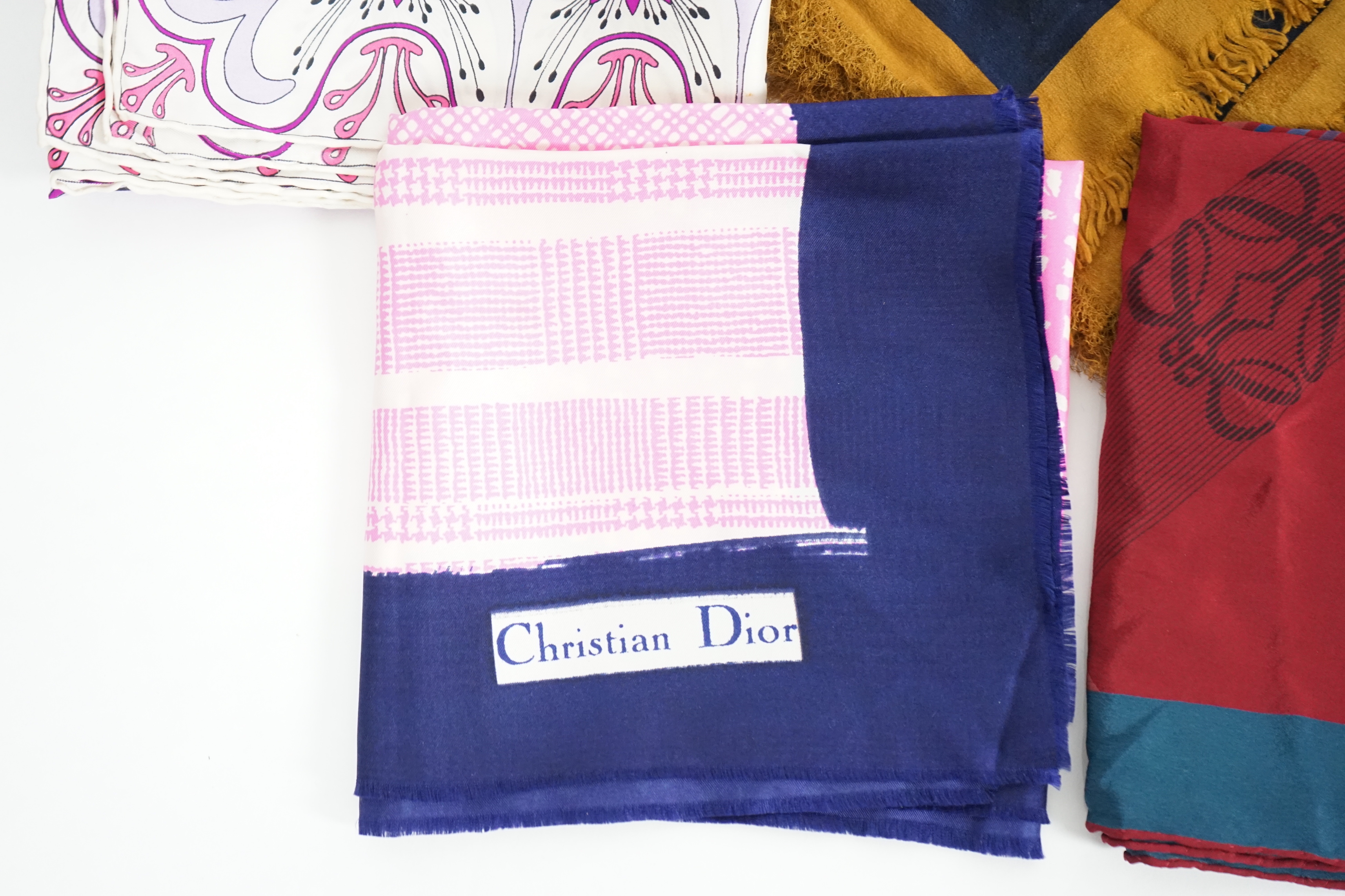 A selection of Yves Saint Laurent, two Christian Dior, Richel and Loewe silk scarves, YSL, 83cm x 85cm Christian Dior: 84cm x 80cm Richel: 87cm x 87cm Loewe: 86cm x 82cm Christian Dior large scarf 120cm x 130cm approx.